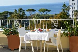 a white table and chairs on a balcony with the ocean at Hotel Crawford in Sant'Agnello