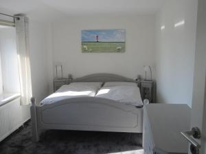 1 dormitorio blanco con 1 cama con faro rojo en Ferienwohnung-England, en Nordstrand