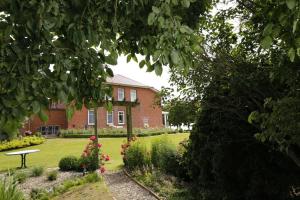 ein Backsteinhaus mit Garten davor in der Unterkunft Ferienwohnung England in Nordstrand