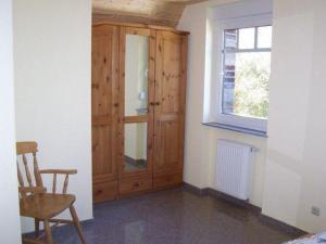 Zimmer mit einem Holzschrank und einem Stuhl in der Unterkunft Zur alten Schmiede II Wohnung unten I in Boltenhagen