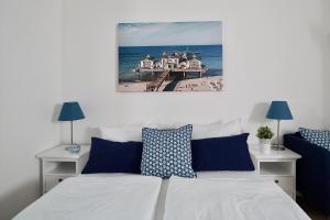 a bed with blue and white pillows in a bedroom at Ferienappartement-Granitz-03 in Ostseebad Sellin