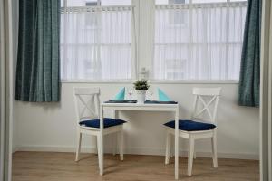 a table and two chairs in a room with windows at Ferienappartement-Granitz-03 in Ostseebad Sellin