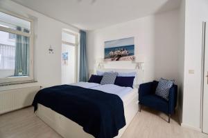 a bedroom with a large bed and a blue chair at Ferienappartement-Granitz-02 in Ostseebad Sellin