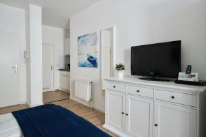 オストゼーバート・ゼリンにあるFerienappartement-Granitz-10のベッドルーム(白いドレッサー、薄型テレビ付)