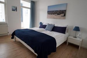オストゼーバート・ゼリンにあるFerienappartement-Granitz-16のベッドルーム1室(大型ベッド1台、青い毛布付)