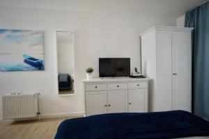 オストゼーバート・ゼリンにあるFerienappartement-Granitz-17のベッドルーム1室(ベッド1台、キャビネット内のテレビ付)