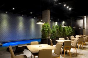 een restaurant met tafels, stoelen en planten bij ASTON Cilegon Boutique Hotel in Cilegon