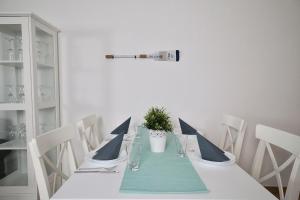 einen Esstisch mit einem blauen Tischtuch und weißen Stühlen in der Unterkunft  Ferienappartement Jasmund 20 in Ostseebad Sellin
