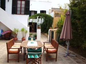 アンドラッチにあるVilla Maria, bonita casa con jardín y piscina privada en Andratxのパティオ(テーブル、椅子、パラソル付)
