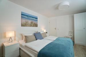 オストゼーバート・ゼリンにあるFerienappartement-Wittow-23の白いベッドルーム(青い毛布付きのベッド付)