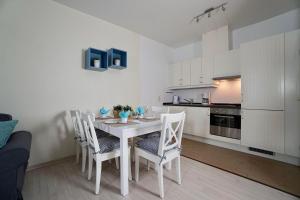オストゼーバート・ゼリンにあるFerienappartement-Jasmund-13の白いキッチン(ダイニングルームテーブル、椅子付)