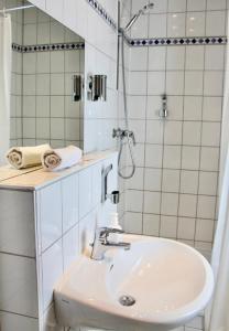 a white bathroom with a sink and a shower at Parkhotel Viktoria in Velten