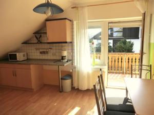 a small kitchen with a table and a balcony at Ferienwohnung Wenz in Poppenhausen