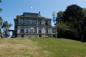 an old house on top of a grassy hill at Kreuzlingen Youth Hostel in Kreuzlingen