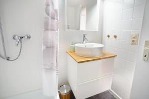 een witte badkamer met een wastafel en een douche bij Alpseenest in Immenstadt im Allgäu