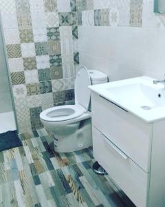 La salle de bains est pourvue de toilettes blanches et d'un lavabo. dans l'établissement Alojamiento Rural La Yuca, à Benaocaz