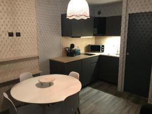 una pequeña cocina con mesa y sillas. en Résidence Dome de Polset - Studio 2 adultes et 2 enfants - Wifi en Val Thorens