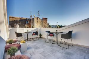een patio met stoelen en tafels op een dak bij Apartment De Ville 2020 with free parking in Pula