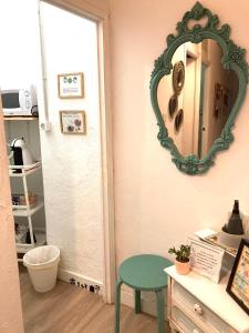 a room with a mirror and a table and a stool at Pensión Cádiz in Cádiz