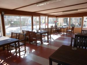 un restaurante vacío con mesas, sillas y ventanas en Oasis Country Park en Rugat