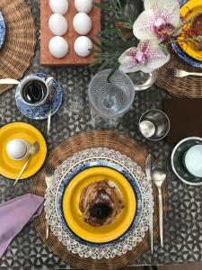 einen Tisch mit Teller mit Lebensmitteln und Eiern darauf in der Unterkunft Casas da Vila in Trancoso
