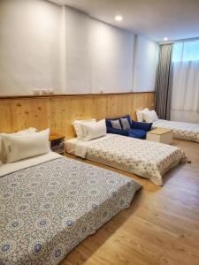 a room with three beds in a room at It's a Good Time Homestay in Guangfu