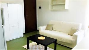 a living room with a white couch and a table at Terza Spiaggia & La Filasca - Apartments in Golfo Aranci