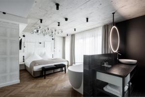 a bathroom with a bed and a tub and a sink at Hotel Sonne in Füssen