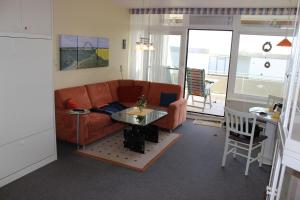 a living room with a couch and a table at Direkt-am-Suedstrand in Burgtiefe auf Fehmarn 