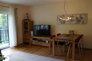 sala de estar con mesa y TV en Ehlershus, en Reit im Winkl