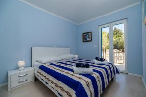 niebieska sypialnia z łóżkiem i oknem w obiekcie Luxury Apartment Marina View No 3 w mieście Vela Luka