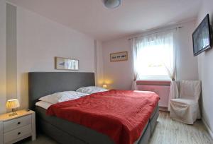 ヘルヌムにあるSternbildのベッドルーム1室(赤毛布、窓付)