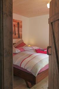 a bedroom with a bed with a wooden frame at Ferienhaus-Rotdorn-Haus-Nord in Strukkamp auf Fehmarn