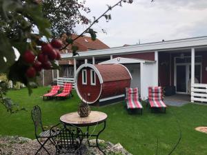 einen Garten mit Stühlen, einem Tisch und einem Gebäude in der Unterkunft Ferienhaus Rotdorn Haus Nord in Strukkamp auf Fehmarn