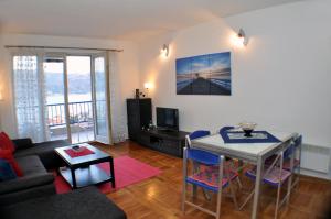 uma sala de estar com uma mesa e um sofá em Belvedere Apartments em Budva