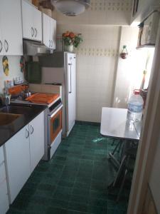 una cucina con pavimenti piastrellati verdi e armadietti bianchi di Vista al mar central a Mar del Plata