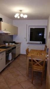 a kitchen with a wooden table and a dining room at Ferienwohnung-Burgblick-in-Neuravensburg in Haggen