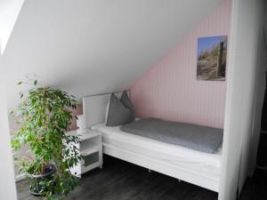 a small bedroom with a bed and a plant at Ferienwohnung-Bullerby in Barkelsby