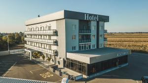 um hotel como edifício com um campo ao fundo em Hotel River em Bijeljina