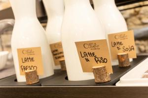 una fila de botellas blancas con signos en ellas en Curt di Clement Eco Mobility Hotel en Tirano