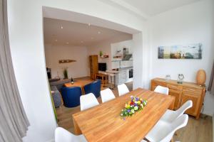 a dining room and living room with a wooden table and chairs at Villa Eden Binz Typ 6 / Apartment 1 in Binz