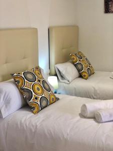 Un dormitorio con dos camas con almohadas encima. en EL MIRADOR DE CACERES, en Cáceres