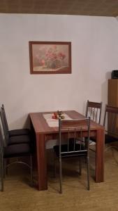 a dining room table with chairs and a painting on the wall at Haus-Sonne in Flöha