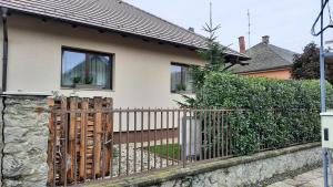 a fence in front of a house at Aranypatak apartmanház in Szombathely