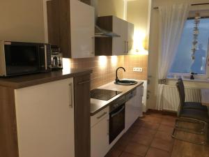 a kitchen with a microwave and a stove top oven at Apartment-Seemoewe-1A-Standlage-nur-150m-mit-Parkplatz in Baabe