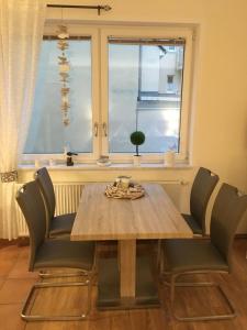 a dining room table and chairs in front of a window at Apartment-Seemoewe-1A-Standlage-nur-150m-mit-Parkplatz in Baabe