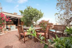 a patio with a wooden table and chairs at Casa Rural El Moral in Lomo de Arico