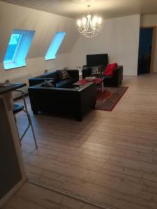 ein Wohnzimmer mit 2 Sofas und einem Kronleuchter in der Unterkunft Ferie Apartment Skovby Fyn in Bogense