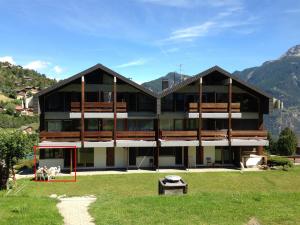 a large building with mountains in the background at Scierie A Meya 118 in Vercorin