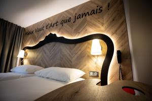 ドゥエーにあるibis Styles Douai Gare Gayant Expoのベッドルーム1室(木製ヘッドボード付きのベッド1台付)